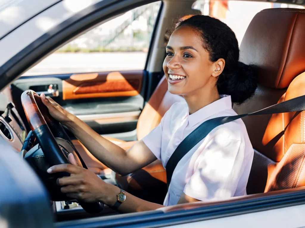 A confident woman drives, symbolizing a fresh start after treatment.