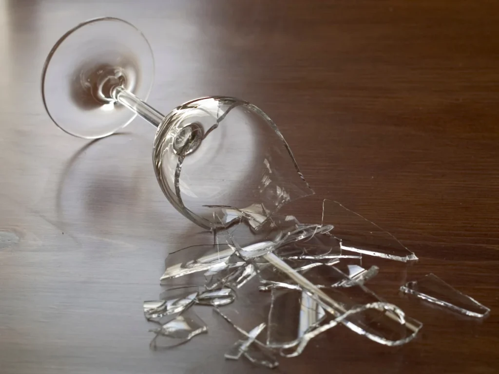 Broken wineglass on a flat surface.